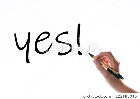 Children hand with pen write on an blue white background. Writing hand. Word YES Children hand with pen write on an blue white background. Writing hand. Word YES 122696039