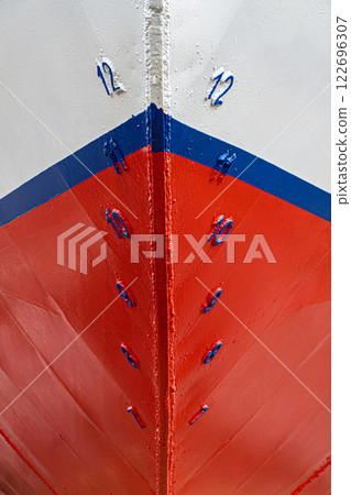 Ship's bow with red, white, and blue paint, featuring blue draft markings on weathered metal and welded seams detailed close-up Ship's bow with red, white, and blue paint, featuring blue draft markings on weathered metal and welded seams detailed close-up 122696307