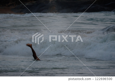 Man Dives Feet-First Into The Sea at Dusk in Sri Lanka Man Dives Feet-First Into The Sea at Dusk in Sri Lanka 122696500