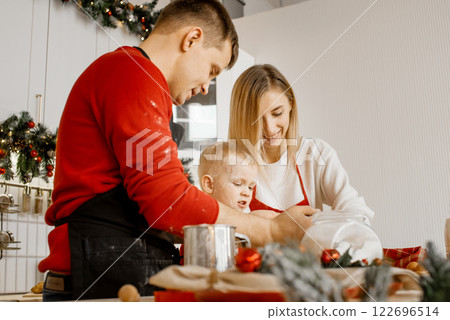 Side view of happy funny family mother, father and little son bake christmas cookies on cozy kitchen at home 122696514