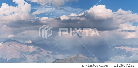 Fantastic snow-capped mountains in the beautiful cumulus clouds. Main Caucasian Ridge. Fantastic snow-capped mountains in the beautiful cumulus clouds. Main Caucasian Ridge. 122697252
