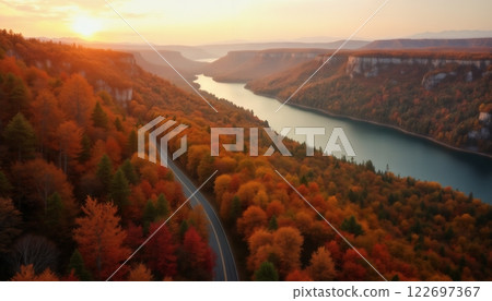 an impressive autumn landscape, forest and mountains against the sunset, a road to the horizon and a lake, sunlight through clouds, beautiful nature 122697367