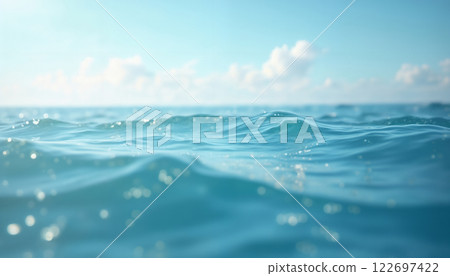 blue surface of ocean water close up, low angle, against background of sky and white clouds, impressive seascape, beautiful and calm water surface 122697422