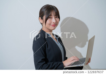 A smiling Japanese woman holding a laptop A smiling Japanese woman holding a laptop 122697637