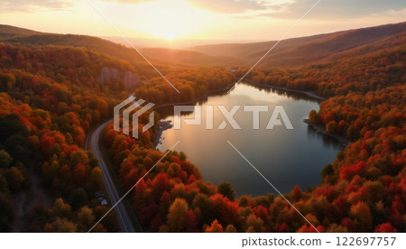 an impressive autumn landscape, forest and mountains against the sunset, a road to the horizon and a lake, sunlight through clouds, beautiful nature 122697757