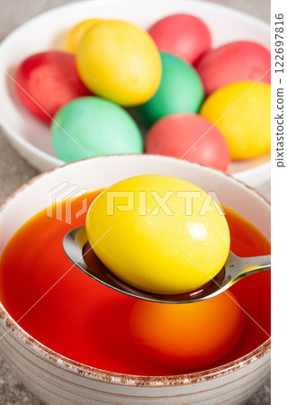 The process of painting eggs for Easter. Eggs in an aqueous dye solution 122697816