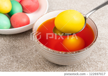 The process of painting eggs for Easter. Eggs in an aqueous dye solution 122697817