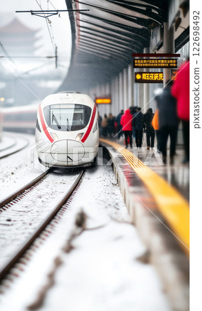 Modern high-speed train at snowy platform with diverse passengers 122698492