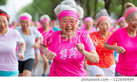 Elderly asian women in pink activewear participating in outdoor marathon event 122698494