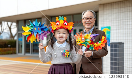 Young asian girl and elderly asian man with colorful paper crafts outdoors Young asian girl and elderly asian man with colorful paper crafts outdoors 122698548
