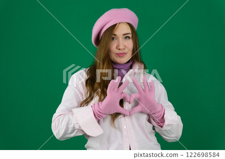 make a heart with your hands Charming young woman with dark long hair makes korean love sign, shapes heart with fingers, wears bright fashionable green beret and jumper on buttons make a heart with your hands Charming young woman with dark long hair makes korean love sign, shapes heart with fingers, wears bright fashionable green beret and jumper on buttons 122698584
