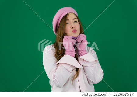 Young stylish woman wearing pink warm coat, pants and handbag walking in the city street in cold season. Winter fashion, elegant look, outfit in pastel colors. Plus size model. 122698587