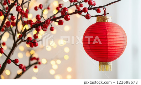 Festive red lantern hanging on branches with glowing lights in the background 122698678