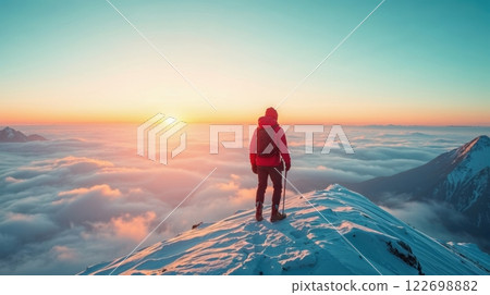 A lone hiker on snowy mountain at sunset 122698882