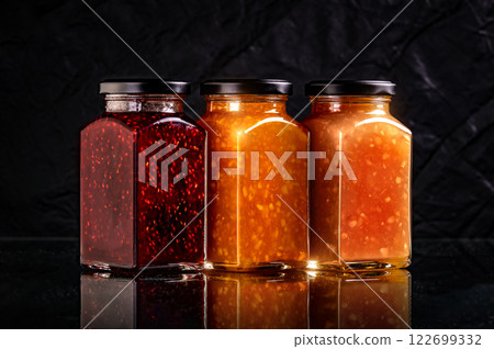 raspberry jam, orange marmalade and ginger lemon canned in glass jar isolated mockup template. sweet food dessert on black background 122699332
