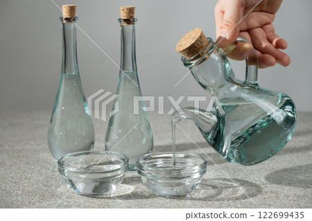White distilled vinegar is poured into a glass vinegar bowl. White distilled vinegar is poured into a glass vinegar bowl. 122699435
