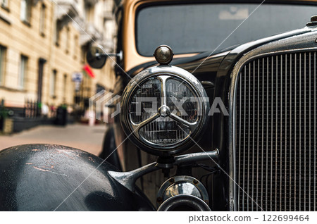 Classic Chevrolet CA vintage car detail shot. Gleaming chrome headlight and grille showcase the car's elegant desig 122699464