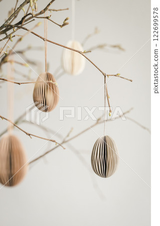 Easter paper eggs hanging on branches. Scandinavian-style Easter decorations. 122699578