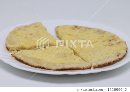 Pita warmed up with cheese lies on a plate, pita cut into pieces, proper nutrition 122699642