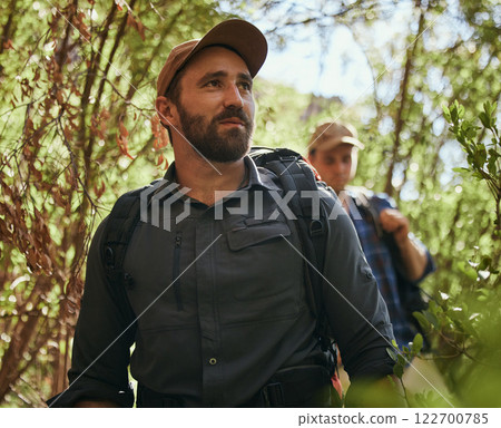 Friends hike in nature environment while journey in a green forest together, being active and bonding outdoor. Male walking on path in the woods, enjoying a physical challenge and trekking adventure Friends hike in nature environment while journey in a green forest together, being active and bonding outdoor. Male walking on path in the woods, enjoying a physical challenge and trekking adventure 122700785
