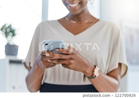 Hands of a business woman on a phone in a modern office chatting, texting or typing. Employee browsing social media, online or sms message or emails on the web or internet device while at work 122700926