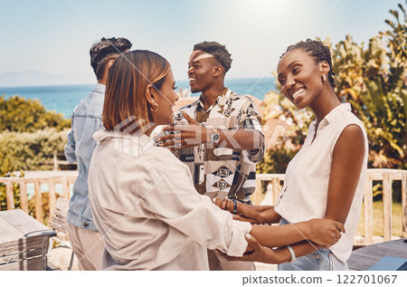 Friends, hugging and looking happy while meeting outside a restaurant. Diverse couples talking and greeting while on a double date. Friendly women and men embracing while having fun at a gathering 122701067