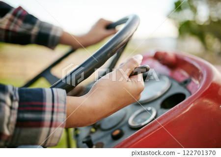 Farm, tractor and agriculture with hands of a farmer driving a vehicle on a farm for sustainability, growth and development in a sustainable and green environment. Farming crops in the harvest season 122701370