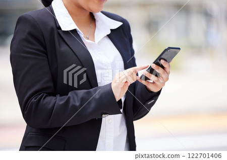 Online, networking business woman in a suit and smartphone reading email communication, WhatsApp or mobile project management app on the go. Corporate professional hands typing on smartphone in city 122701406
