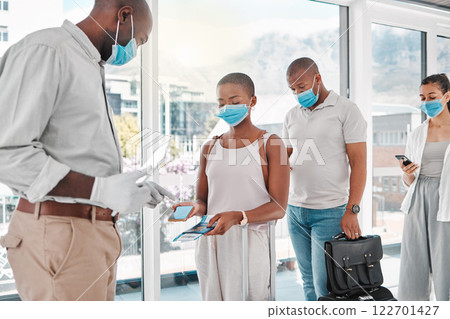 People checking in to the airport to travel during covid pandemic with face masks and luggage. Travelers showing their digital ticket and passport to the airline attendant to board the airplane. People checking in to the airport to travel during covid pandemic with face masks and luggage. Travelers showing their digital ticket and passport to the airline attendant to board the airplane. 122701427