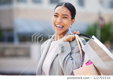 Shopping, retail and sale with a young woman in the city to spend money and shop at a store or mall. Portrait of a happy, carefree and urban customer with a smile holding bags out on the town Shopping, retail and sale with a young woman in the city to spend money and shop at a store or mall. Portrait of a happy, carefree and urban customer with a smile holding bags out on the town 122701510