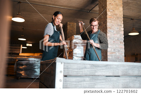 Wine making, production and cellar workers holding press tool to crush, blend and stir open tank for alcohol process. Vintner, factory and winery industry with distillery and manufacturing warehouse Wine making, production and cellar workers holding press tool to crush, blend and stir open tank for alcohol process. Vintner, factory and winery industry with distillery and manufacturing warehouse 122701602