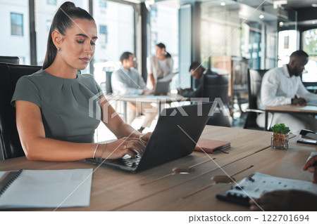 Business woman on a computer at a startup company, working on email. Girl in corporate management at a desk on the internet in tech office or a web designer learning to design a website on a laptop. 122701694