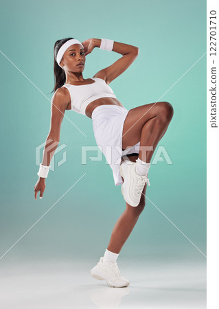Fit, athletic and cute female tennis player or athlete woman with a cool attitude stretching in a green studio. Portrait of an active, trendy and sporty lady ready for training or a match Fit, athletic and cute female tennis player or athlete woman with a cool attitude stretching in a green studio. Portrait of an active, trendy and sporty lady ready for training or a match 122701710