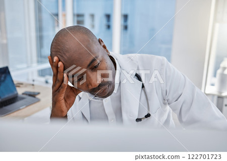 Stress, anxiety and sad doctor at work on computer, sick and headache in a hospital or clinic. Medical professional or healthcare worker in depression, burnout and working and thinking about health. 122701723