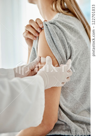 Covid, vaccine and doctor applying plaster to patient after receiving medical treatment during pandemic. Close up of healthcare worker putting on medic patch after consulting a woman at hospital. 122701833
