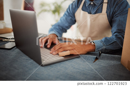 Online order, fashion designer or tailor typing invoice, browsing and searching internet for clothing inspiration. Closeup hands of man in workshop, studio and boutique for trendy and stylish clothes Online order, fashion designer or tailor typing invoice, browsing and searching internet for clothing inspiration. Closeup hands of man in workshop, studio and boutique for trendy and stylish clothes 122701923