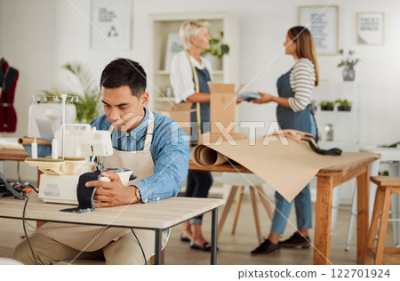 Tailor, seamstress and creative designer working on a sewing machine in a design studio or workshop. Fashion, style and creativity with a young man knitting and stitching while making trendy clothing Tailor, seamstress and creative designer working on a sewing machine in a design studio or workshop. Fashion, style and creativity with a young man knitting and stitching while making trendy clothing 122701924