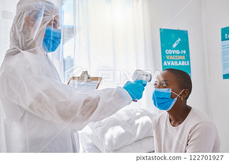 Covid screening, measuring temperature and mask wearing with a doctor treating a patient in the hospital. Health, safety and medicine with a female medical practitioner and healthcare professional 122701927