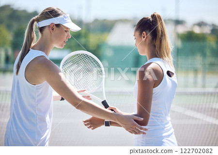 Tennis coach giving sports lesson to athlete for sporty, summer exercise, activity or hobby on outdoor court. Female instructor teaching and training woman for fitness, leisure or wellness lifestyle. 122702082