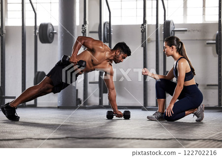 Muscular, sports man with female gym instructor or fitness coach doing body building workout, push up plank exercise. Active male athlete weightlifting in wellness center with trainer for motivation. Muscular, sports man with female gym instructor or fitness coach doing body building workout, push up plank exercise. Active male athlete weightlifting in wellness center with trainer for motivation. 122702216