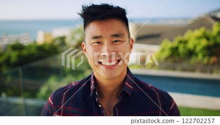 Outdoor, portrait and Asian man with smile, travel and summer holiday with adventure. Japanese person, traveller or guy with weekend break, vacation and explore with journey, ocean or positive energy 122702257