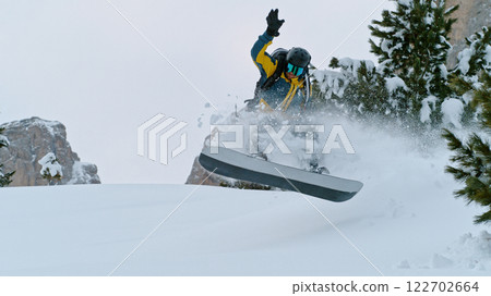 Snowboard rider jumping in fresh powder during sunny day , Alpine scenery 122702664