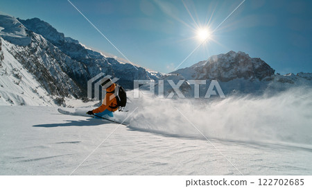 Skier riding in the scenic Alps mountains in fresh powder snow , beautiful sunny day 122702685