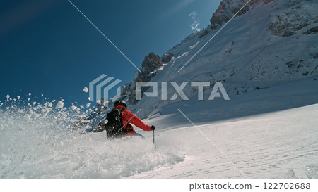Skier riding in the scenic Alps mountains in fresh powder snow , beautiful sunny day 122702688