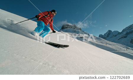 Skier riding in the scenic Alps mountains in fresh powder snow , beautiful sunny day 122702689