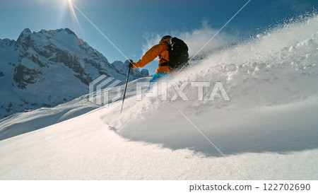 Skier riding in the scenic Alps mountains in fresh powder snow , beautiful sunny day 122702690