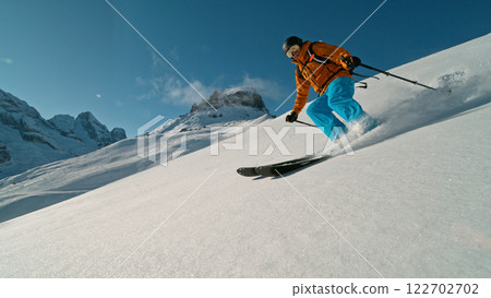 Skier riding in the scenic Alps mountains in fresh powder snow , beautiful sunny day Skier riding in the scenic Alps mountains in fresh powder snow , beautiful sunny day 122702702