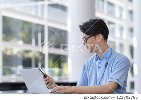 Image of a facility staff member operating a smartphone 122702760