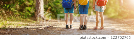 Three children standing along a path in a summer forest. Three children standing along a path in a summer forest. 122702765