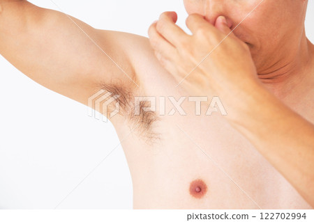 Middle-aged man smelling his armpits Middle-aged man smelling his armpits 122702994